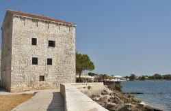 La passeggiata del lungomare di Umago (Croazia) e un'antica casa in pietra proprio in riva all'Adriatico.
