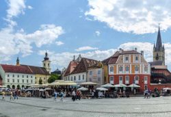 Turisti nella Piazza Piccola di Sibiu, Romania - Collegata alla Piazza Grande da alcuni stretti passaggi, "Piata Mica" (ovvero Piazza Piccola) è caratterizzata dalla curvatura ...