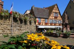 La piazza principale del borgo alsaziano di Eguisheim, Francia. Sullo sfondo, un antico palazzo a graticcio - © Claudiovidri / Shutterstock.com