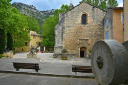 La piazza principale di Fontaine-de-Vaucluse, Provenza, Francia, con un la chiesa e un mulino in pietra.
