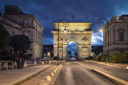 La Porta di Peyrou, l'arco di trionfo di Montpellier, di notte (Francia). Dedicato a Luigi XIV°, ha superficie ruvida in stile rustico che termina con una trabeazione dorica.
