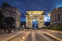 La Porta di Peyrou, l'arco di trionfo di Montpellier, di notte (Francia). Dedicato a Luigi XIV°, ha superficie ruvida in stile rustico che termina con una trabeazione dorica.
