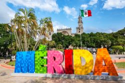 La scritta colorata Merida con la bandiera messicana e la cattedrale cittadina sullo sfondo, Messico  - © Jess Kraft / Shutterstock.com