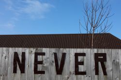 La scritta never (mai) su un pannello di legno a Nevers, Francia.
