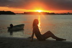 La silhouette di una giovane donna al tramonto a Boca Chica bay, Repubblica Dominicana.
