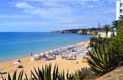 La spiaggia di Armacao de Pera con sdraio e ombrelloni, Portogallo. Questa cittadina ospita alcune delle spiagge più belle di tutto l'Algarve.
