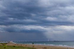 La spiaggia di Punta Marina in estate durante un temporale. La diga foranea di Marina di Ravenna sullo sfondo