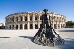 La statua del torero con l'arena sullo sfondo, simboli della cittadina di Nimes (Francia).
