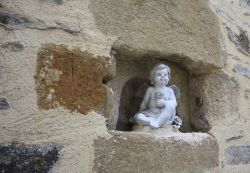 La statua di un angioletto nella nicchia di una chiesa di Beaulieu-sur-Dordogne, Francia.

