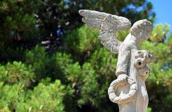 La statua in pietra di un angelo con un anello di pane in mano a Avola, Sicilia.
