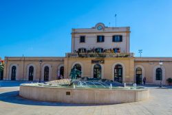 La stazione ferroviaria di Trani, Puglia. In primo piano, una fontana con scultura - © trabantos / Shutterstock.com