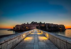 La strada che collega la terraferma a Sveti Stefan, Montenegro, illuminata di notte.
