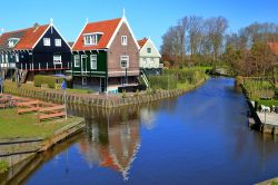 L'acqua di un canale con i riflessi dei tipici edifici in legno a Marken, Olanda - © Inu / Shutterstock.com