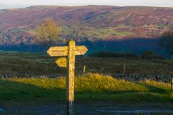 Le indicazioni verso Pwll Du, Gilwern Hill e Tyla illuminate dagli ultimi raggi di sole a Abergavenny, Galles, UK.

