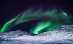 Le luci dell'autora boreale nel cielo norvegese delle Svalbard. Siamo fra le montagne della città di  Longyearbyen.
