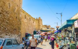 Le mura della Medina di Sfax, Tunisia. Lungo un tratto della cinta muraria di questo quartiere sorge il tradizionale mercato all'aperto con decine di bancarelle di prodotti di ogni genere ...