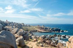 Le rocce sulla costa dell'isola di Lavezzi, Corsica. Sullo sfondo, il faro a emissione luminosa tramite lampada alogena da 80 W.
