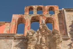 Le rovine di una vecchia chiesa nella città di Guanajuato, Messico: facciata rosa con sei arcate e elaborati dettagli in pietra.

