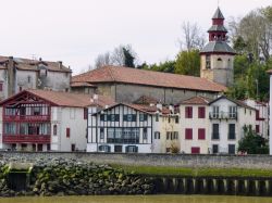 Le tipiche case basche nel centro di Saint-Jean-de-Luz, Francia, con la torre campanaria - © LOCUBROTUS / Shutterstock.com