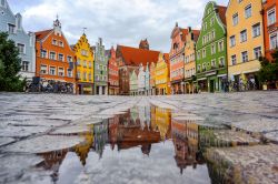 Le tipiche case gotiche della vecchia Landshut, Baviera, Germania, riflesse in una pozza d'acqua dopo la pioggia. 

