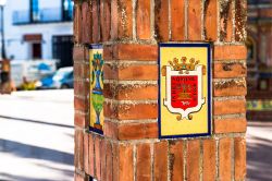 Lo stemma della città di Vejer de la Frontera, Spagna. Roporta la scritta "In dei nomine amen".
