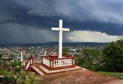 Loma de la Cruz a Holguin, Cuba. Un cielo grigio e cupo sovrasta la Hill of the Cross dove è stata innalzata una croce in legno. Si tratta di uno dei luoghi simbolo della città ...