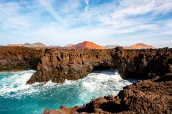 Los Hervideros: la costa battuta dalle onde dell'Oceano Atlantico. Sullo sfondo i vulcani, immancabili nel panorama di Lanzarote (Canarie).