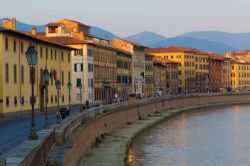 Lungofiume di Pisa alla sera, Toscana. Secondo una leggenda, la città di Pisa sarebbe stata fondata da alcuni profughi troiani provenienti dall'omonima cittadina greca.

