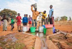 Malawi con secchi e contenitori d'acqua a una pompa di erogazione vicino a Lilongwe - © Andrea Willmore / Shutterstock.com