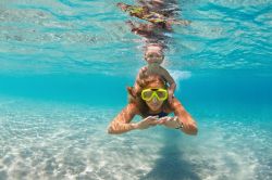 Mamma e bambino fanno snorkeling e nuotano sott'acqua nel mare a Inagua, arcipelago delle Bahamas. E' una delle tante attività sportive che si possono praticare in quest'isola ...