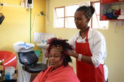 Marsabit, Kenya: una giovane ragazza realizza un'acconciatura nel centro di formazione professionale per ottenere l'abilitazione finale - © Adriana Mahdalova / Shutterstock.com