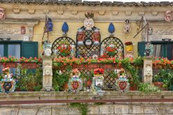 Maschere artistiche sulla facciata di un negozio d'artigianato nel centro storico di Palazzolo Acreide in Sicilia - © Giambattista Lazazzera / Shutterstock.com