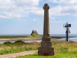 Memoriale della Guerra a Lindisfarne (Inghilterra) con il castello sullo sfondo - © Greenybot / Shutterstock.com