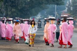 Monaci buddhisti per le strade di Bagan, Myanmar.  Con i tradizionali copricapo per raccogliere l'elemosina questi religiosi camminano per le vie della città di Bagan - © ...
