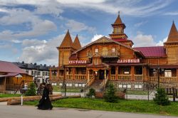 Un monaco passeggia per le vie di Tobolsk, Russia. Sullo sfondo, il ristorante Ladeyny ospitato in un edificio costruito in legno - © Sergei Butorin / Shutterstock.com