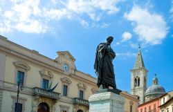 Monumento a Ovidio Naso in Piazza XX° Settembre a Sulmona, Abruzzo, con la torre campanaria sullo sfondo.


