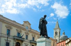 Monumento a Ovidio Naso in Piazza XX° Settembre a Sulmona, Abruzzo, con la torre campanaria sullo sfondo.

