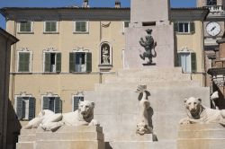 Monumento con sculture nel centro storico di Jesi, Marche. In primo piano, due statue di leoni.

