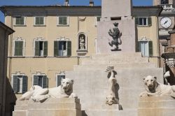 Monumento con sculture nel centro storico di Jesi, Marche. In primo piano, due statue di leoni.

