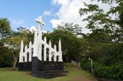 Monumento religioso a Roseau, isola di Dominica, America Centrale. Una croce con Gesù circondata dalla rigogliosa foresta dell'isola.


