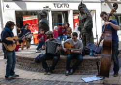 Musicisti di strada suonano dal vivo vicino a una statua nel centro di Chartres, Francia - © Elena Dijour / Shutterstock.com