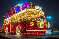 Natale a Varsavia, Polonia: illuminazione a forma di pulmino con pacchi regalo sul tetto.
