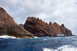 Un'imbarcazione turistica tra le scogliere di Scandola, in Corsica - le imbarcazioni che propongono la visita della bellissima Riserva naturale di Scandola partono da numerose località ...
