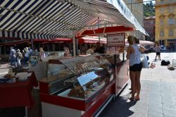 Una bancarella di specialità gastronomiche in corso Saleya a Nizza, Francia. Se volete gustare la socca, farinata di ceci, potete recarvi nell'area di Cours Saleya dove ne troverete ...