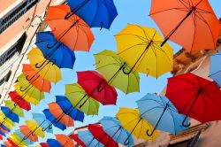 Ombrelli colorati decorano una strada dello shopping nella città vecchia di Novigrad, Croazia.

