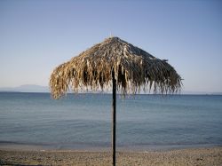 Ombrellone di paglia sulla spiaggia di Angistri, Grecia. Siamo nel golfo Saronico fra Egina e il Peloponneso; dal punto di vista amministrativo questo territorio fa parte della regione dell'Attica ...