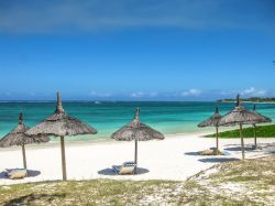 Ombrelloni di paglia nella famosa spiaggia di Belle Mare, Mauritius - Perla della costa orientale di Mauritius, la spiaggia di Belle Mare è fra le più suggestive di questo paradiso ...