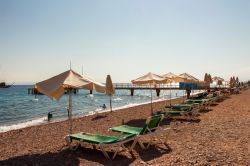 Ombrelloni e sdraio su una spiaggia di Eilat, Israele. Questo mare è perfetto per le attività sportive ma anche per la concentrazione salina che ha consentito lo sviluppo di formazioni ...