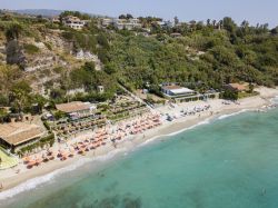 Ombrelloni e sdraio sulla spiaggia di Ricadi nei pressi del villaggio di Torre Marino, Calabria.

