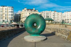 Opera d'arte dell'artista Hamish Black al molo di Brighton, Inghilterra. Sullo sfondo, palazzi antichi della città - © ShutterStockStudio / Shutterstock.com